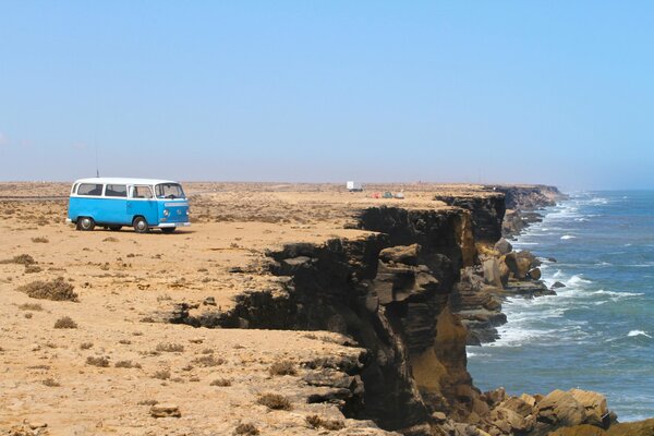 Minibus au pied de la montagne sur fond de mer avec des vagues