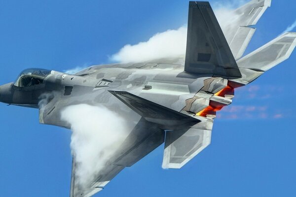 Caccia militare f-22 durante il superamento della barriera del suono in volo