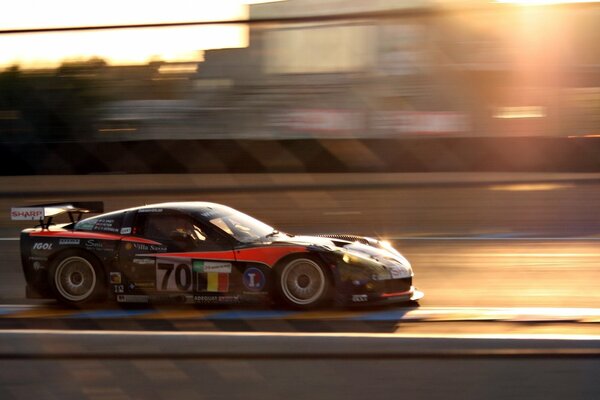 High-speed Corvette on the highway early in the morning. Sports car in the rays of the rising sun