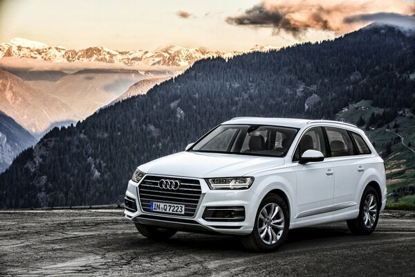 Audi q7 white on the background of a wooded mountain