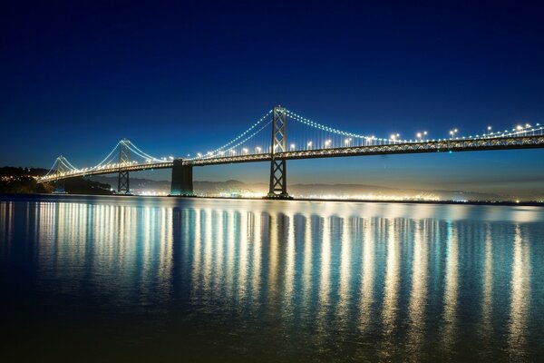 W nocy w San Francisco świecą reflektory na moście