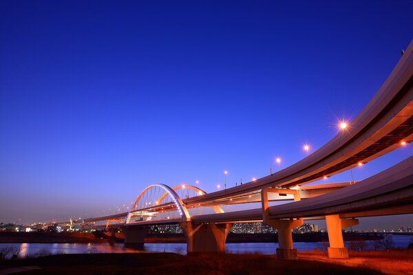 Illuminated bridge over the river at night