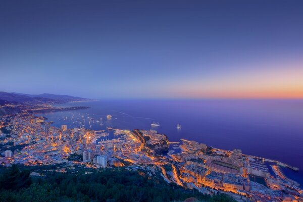 Ciudad en la costa en las luces del atardecer