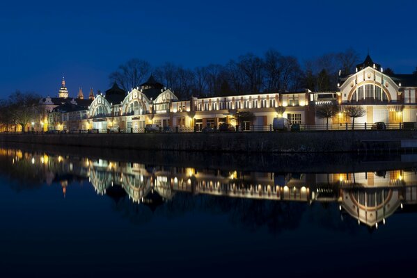 Ville de nuit dans les lumières le long de la rivière