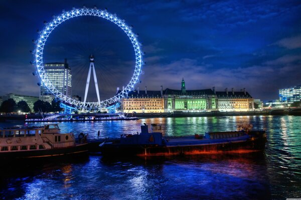 Ferris wheel and night lights in the reflection of the river