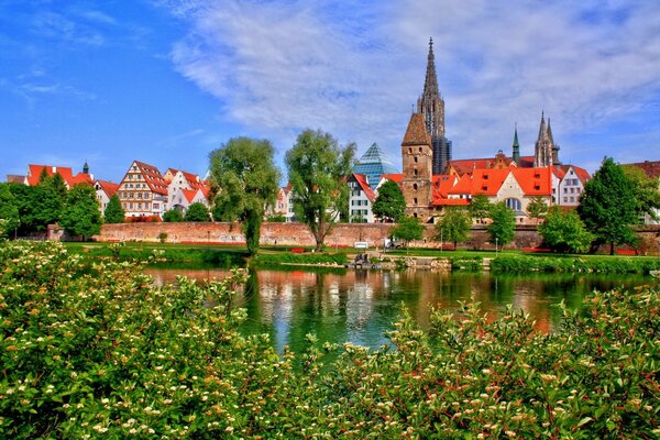 Häuser vor dem Hintergrund von Flüssen und grünen Bäumen in Bayern