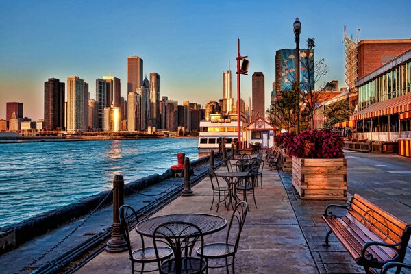 Amanecer en Chicago. Mesas en el paseo marítimo. Ciudad