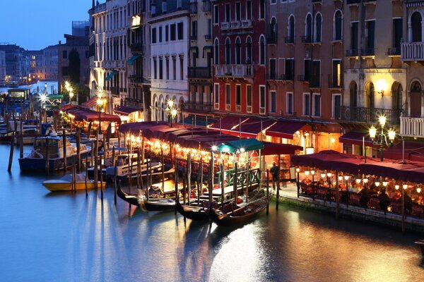 Gondolas on the pier in Venice. Italy at night, a channel lit by lanterns