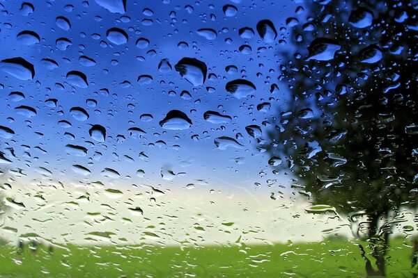 Cielo azul sobre fondo de cristal en gotas