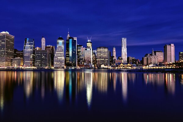 The skyscrapers of evening New York are reflected in the water