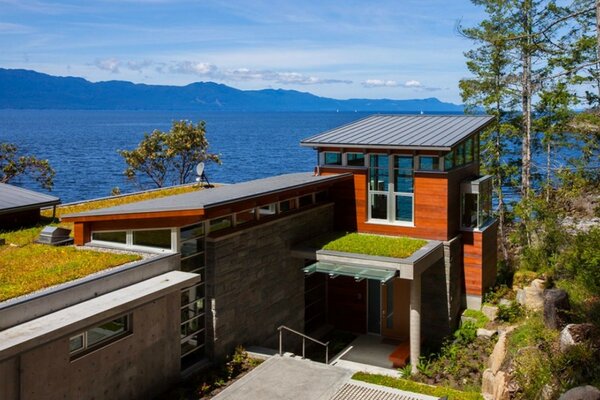 Casa architettonica con sfondo di mare e montagne