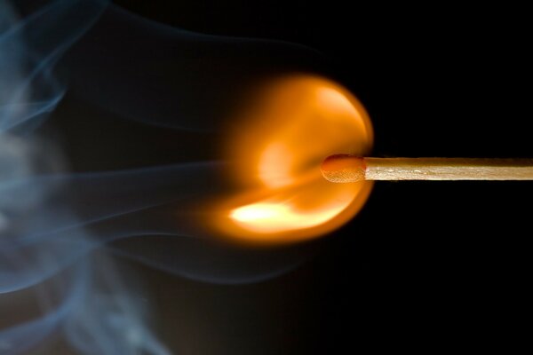 A lighted match. Flame and smoke in macro photos