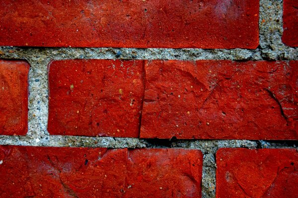 A fragment of a brick wall of bright red color