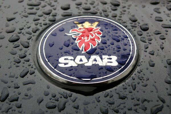 Значок авто Saab под каплями дождя