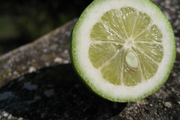 Un morceau de citron vert repose sur la pierre