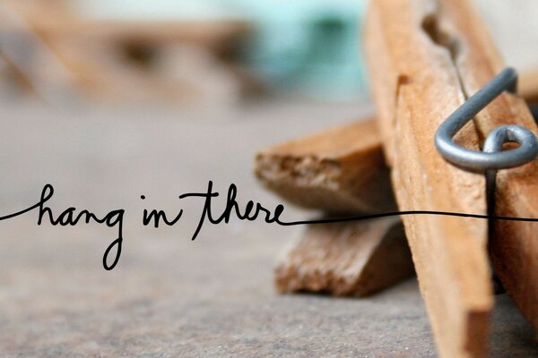 Two wooden clothespins close-up with the inscription in ink on top of the photo