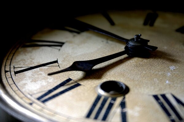 Hands on an old clock with Roman numerals