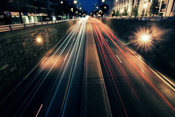 Camino nocturno en el tráfico de los coches de la foto con la exposición