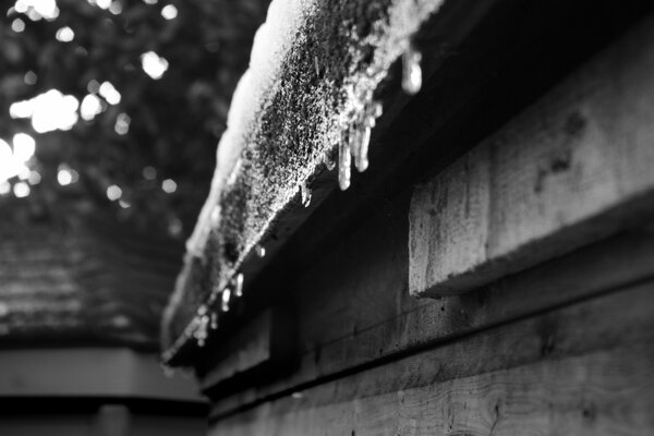 Glaçons suspendus à une maison en bois