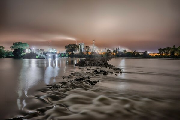 The night city shines with lights reflected in the river