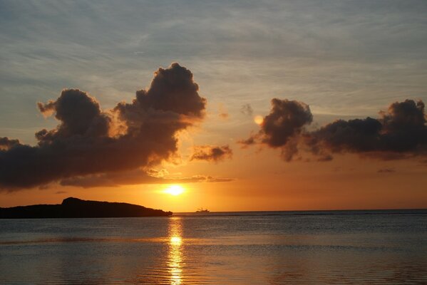 Sunset in the clouds on the background of the coast