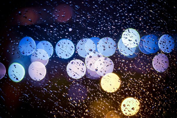 Gotas en el vidrio y la luz de las linternas