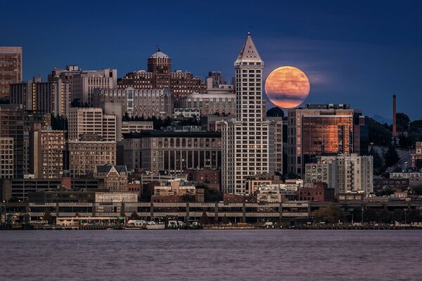 Fiery moon on the background of the urban landscape