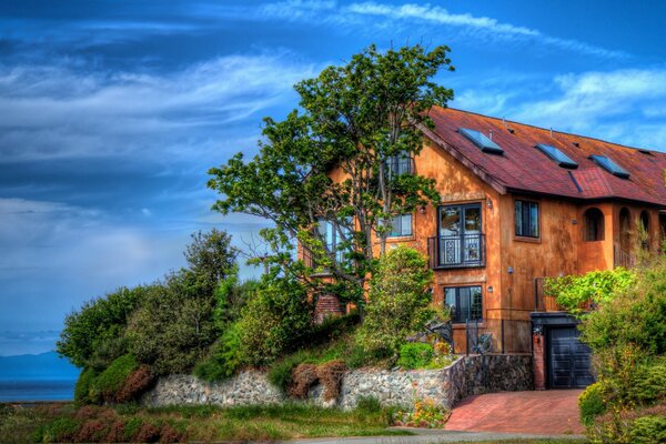 Foto eines Landhauses in der Nähe eines großen Baumes