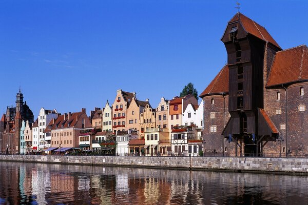 Die Stadt spiegelt sich im Fluss vor dem Hintergrund des blauen Himmels wider