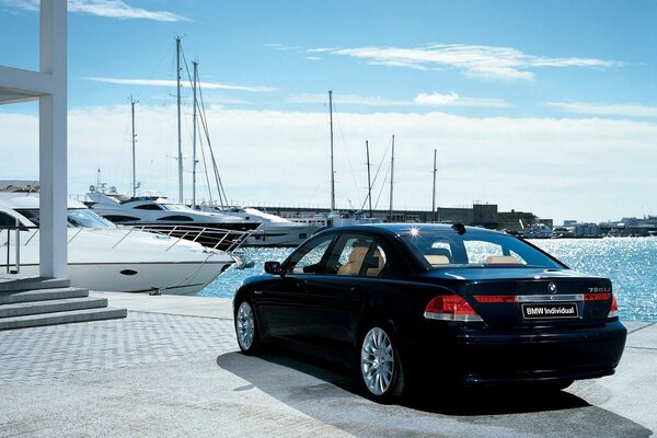 Schwarzer BMW auf dem Hintergrund von Yachten und klarem blauem Himmel