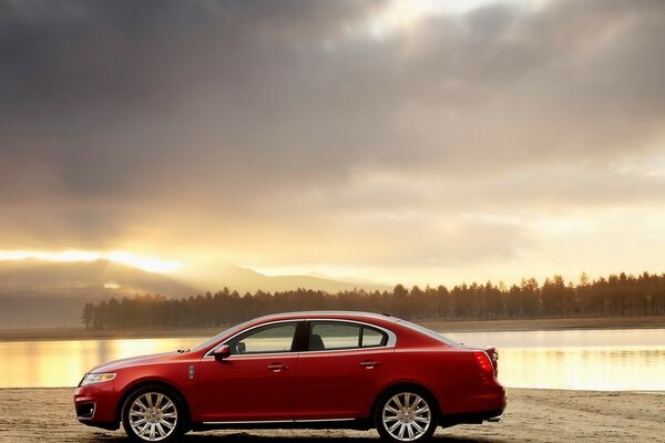 Car on the shore of the lake and against the background of the forest