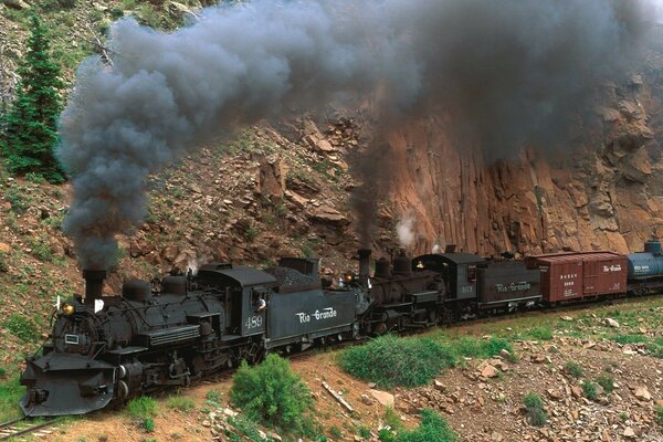 Steam locomotive on rails against the background of mountains