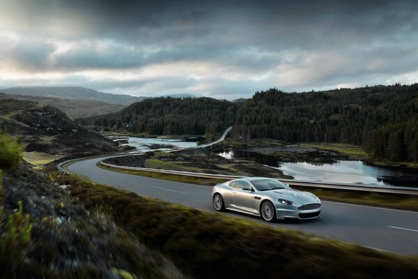 Silver Aston-Martin corre lungo la strada