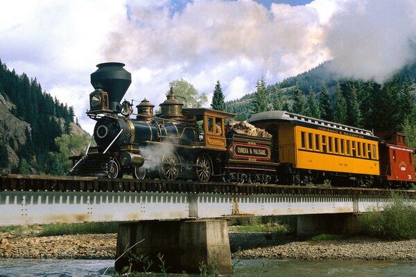 Una locomotora de vapor a Hogwarts recorre un puente sobre un río