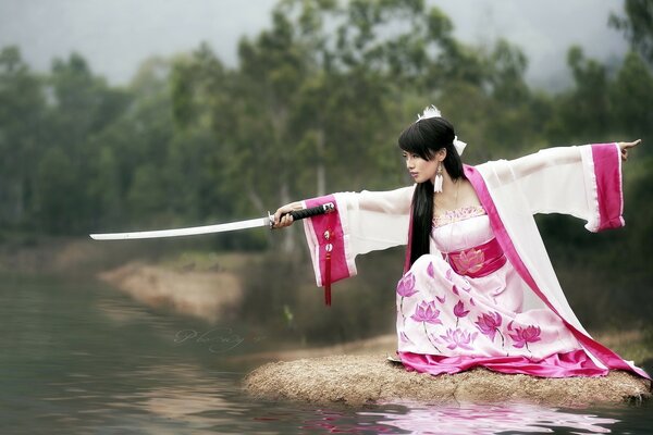 Japanese girl by the lake with a katana