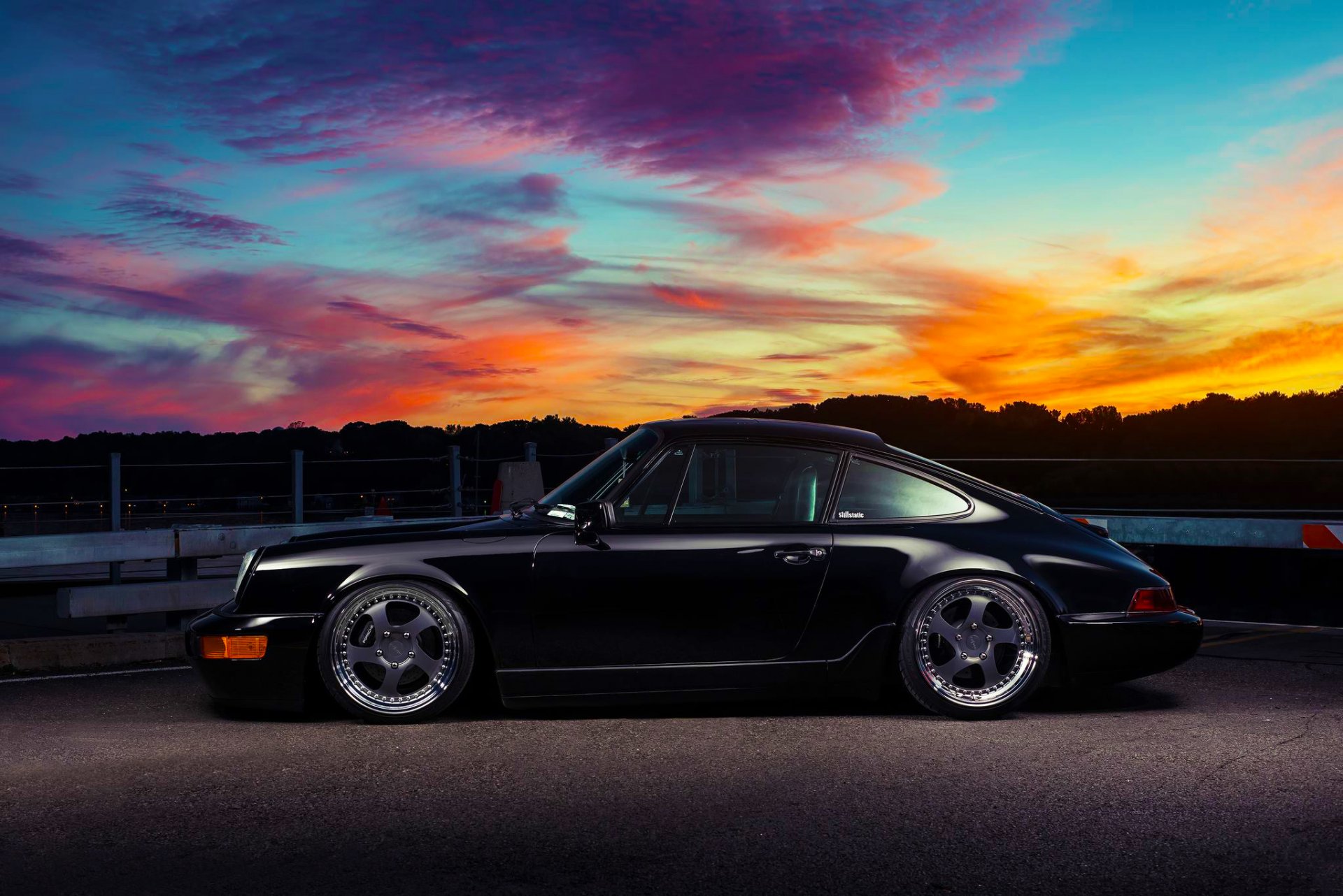 porsche 911 carrera clásico negro lado puesta de sol