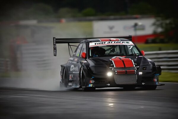 Voiture noire mitsubishi se précipitant sur la piste de course