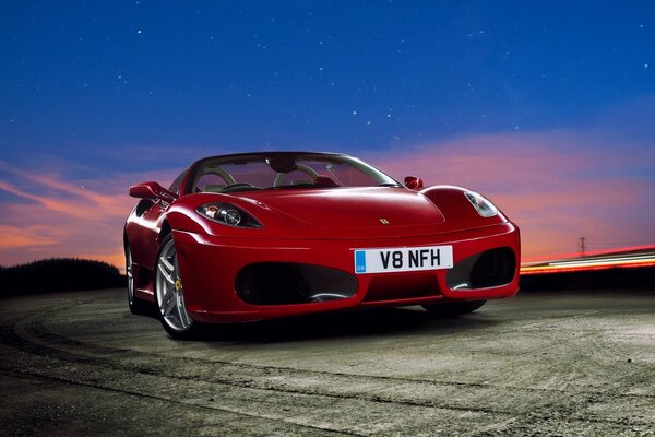 Coche rojo en el fondo del cielo al atardecer