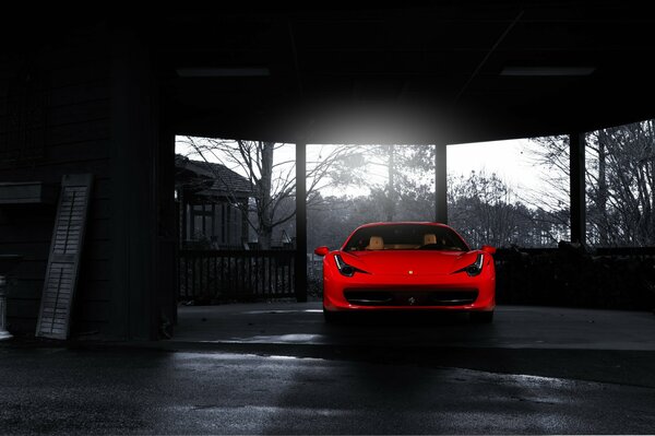 A bright red Ferrari in the center of a black and white photo