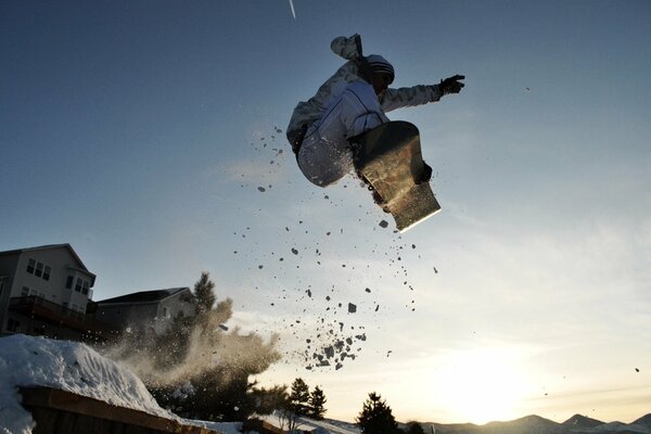 Snowboarder nel salto con gli sci nel villaggio