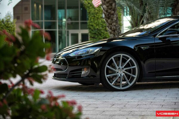 Tesla Model s sur fond de façade de bâtiment