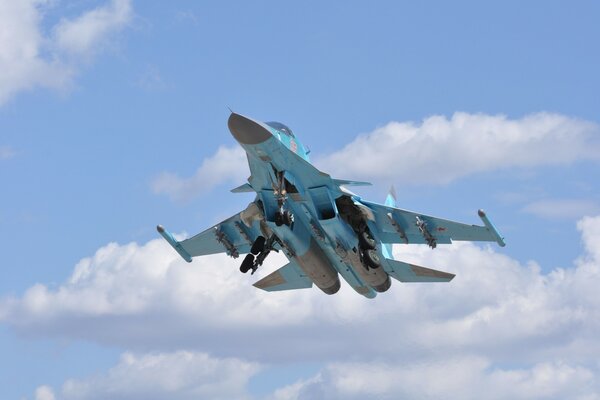 In blauen Wolken ein fliegendes Su-34-Flugzeug