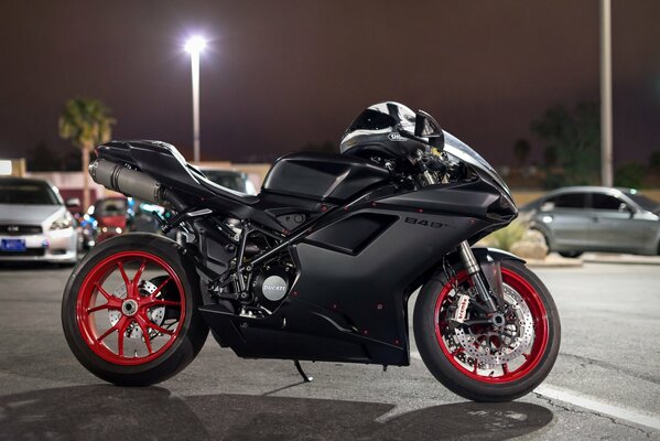 Black ducati motorcycle in the night parking lot