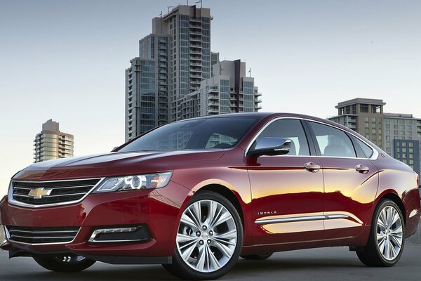 Red chevrolet on the background of high-rise buildings