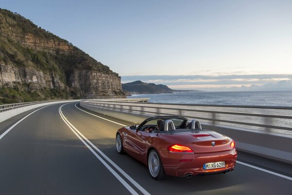 A beautiful red convertible on the background of a cool landscape