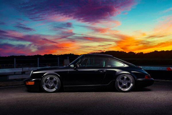Klassischer schwarzer Porsche bei Sonnenuntergang