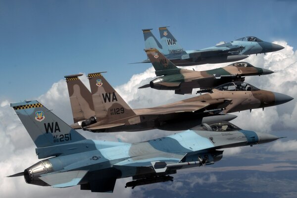 Four fighter jets flying in the clouds