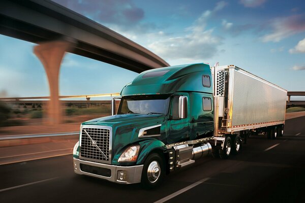 A green Volvo tractor is flying on the motorway