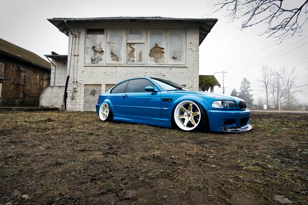 BMW azul en el fondo de una casa abandonada