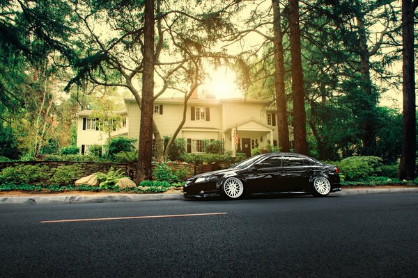 Honda accord acura black on the road near the house